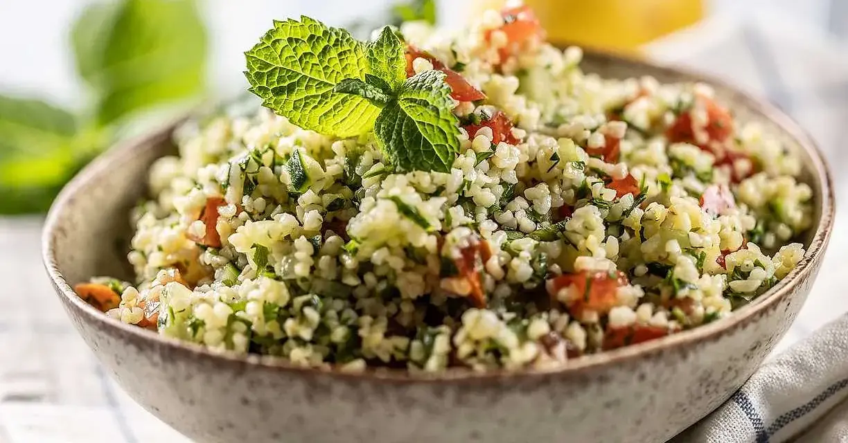 En skål med färgglad tabbouleh, en sallad där man kan koka bulgur med tomat, persilja och mynta.