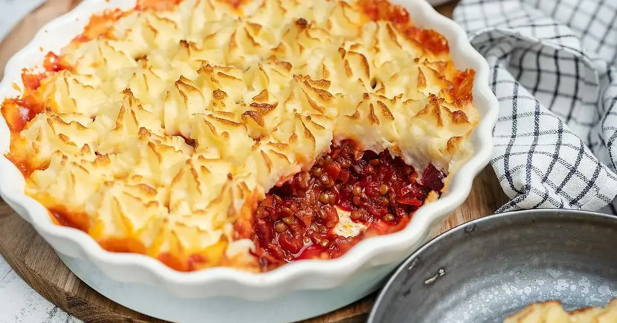 En gyllene shepherd's pie med potatismoslock, fylld med en mustig lins- och rotfruktsröra. Serveras med rödbetor.