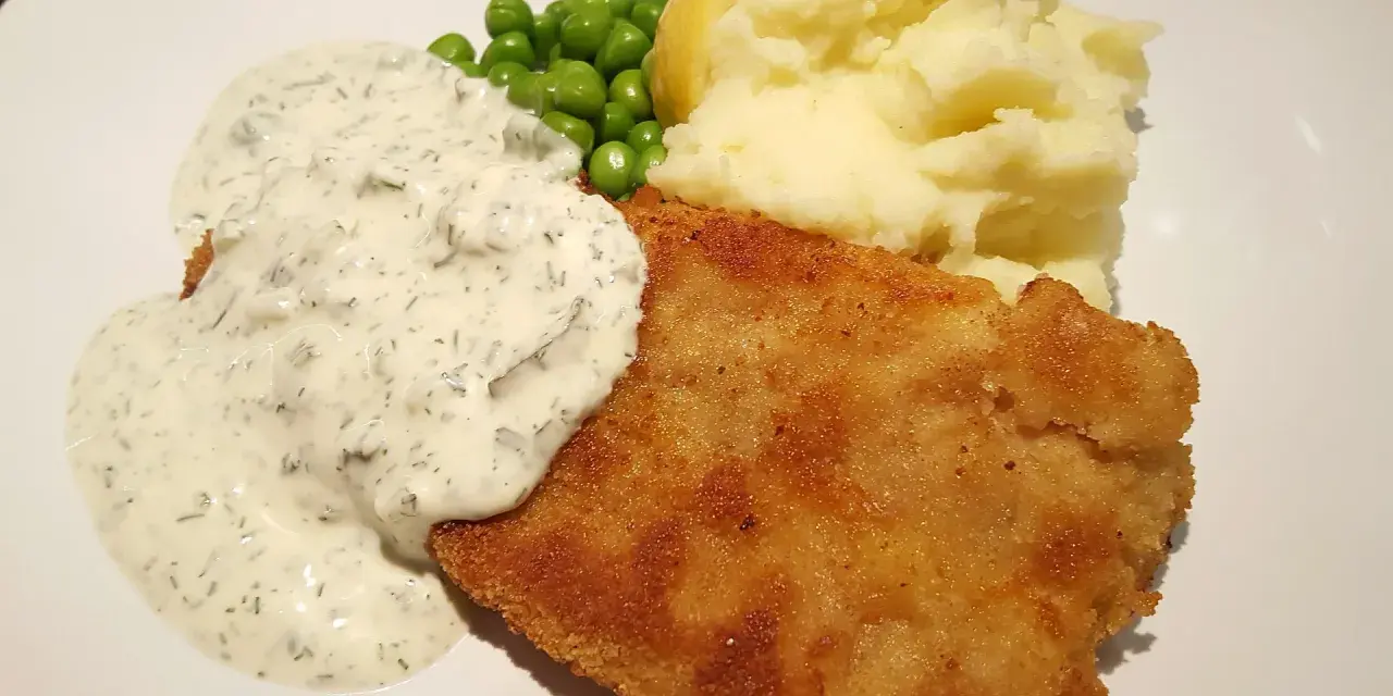 En gyllene panerad fisk med krämig sås, ärtor och potatismos. En klassisk och god måltid.