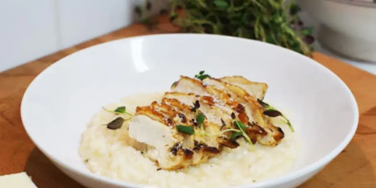 En krämig risotto med kyckling, toppad med färska örter och en bit parmesan. En perfekt risotto med kyckling för en härlig middag.