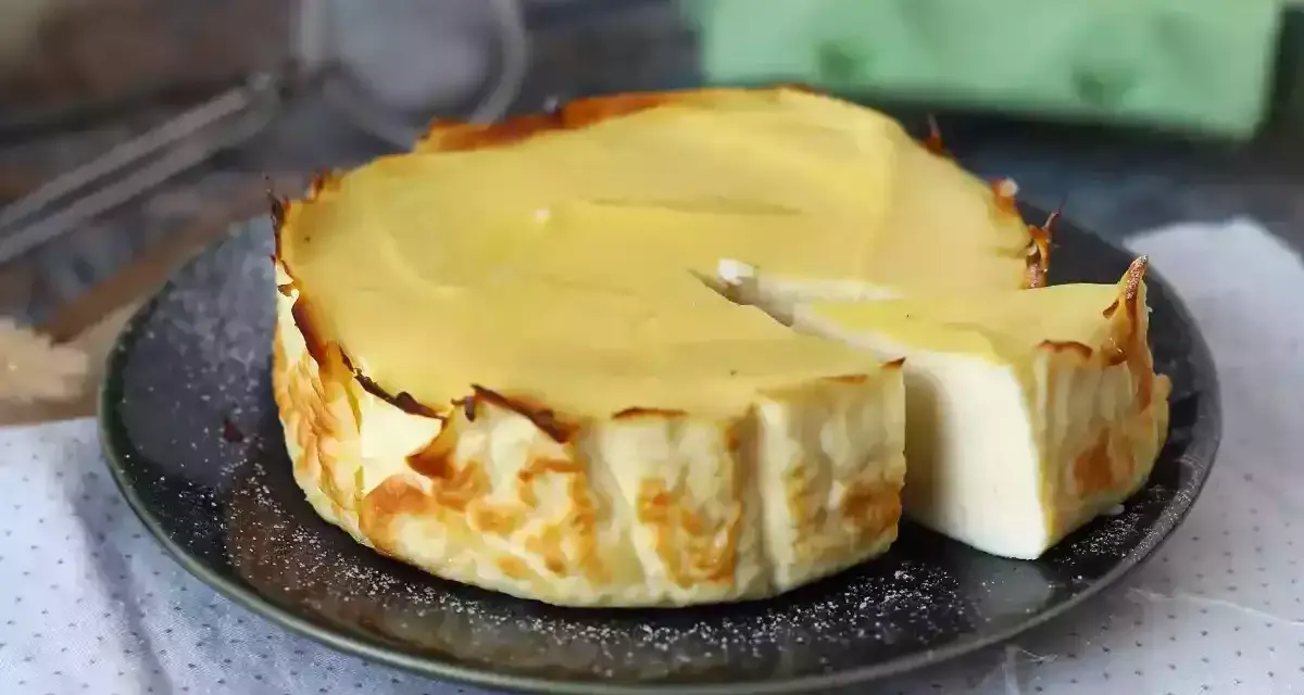 En krämig ricotta cheesecake, perfekt för ett enkelt ricotta recept. En bit är uppskuren och visar den lena insidan.