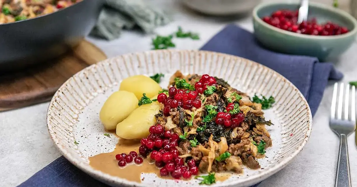 En tallrik med köttfärs och kål, serverad med kokt potatis och lingon. Ett härligt kålmaja recept som ser utsökt ut!