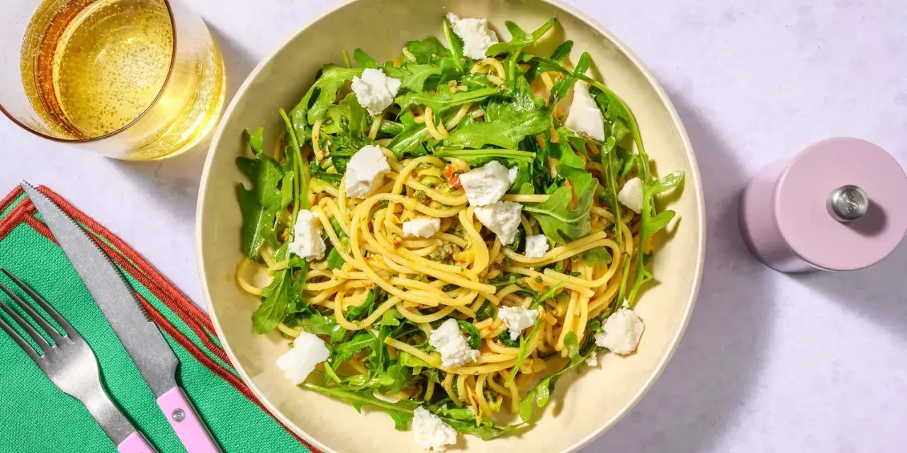 Spaghetti med ruccola och fetaost, ett enkelt zucchini recept. Serveras med ett glas bubbel.