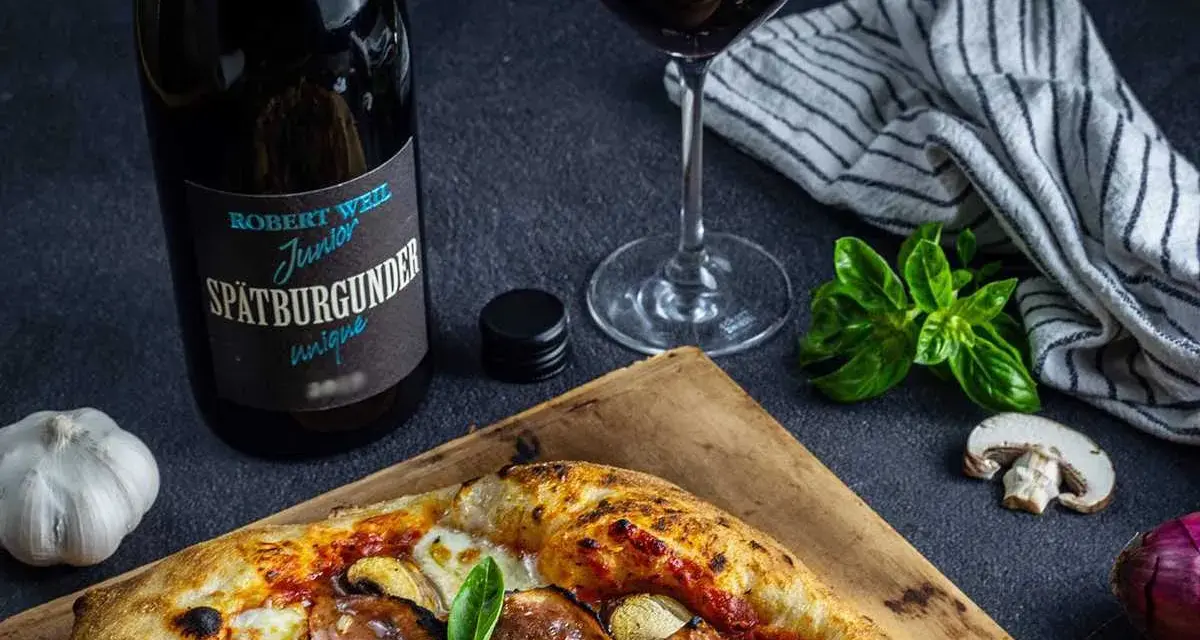 En pizza med svamp och skinka, en flaska Spätburgunder och ett glas rött vin. Perfekt vin till gås!