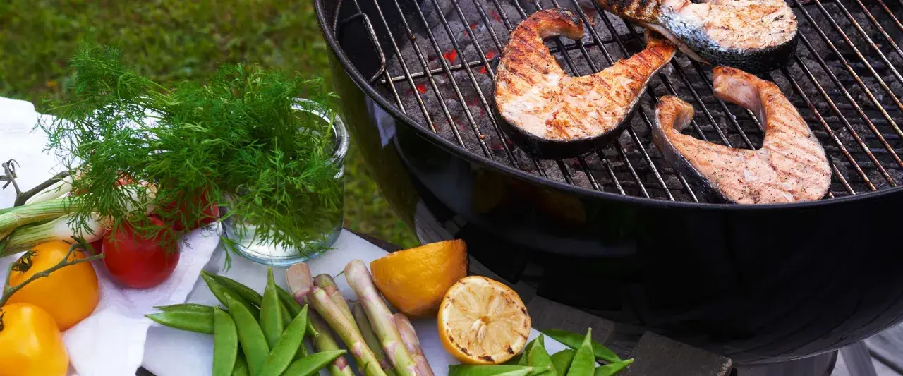 Grilla lax på gasolgrill med färska grönsaker och citron.