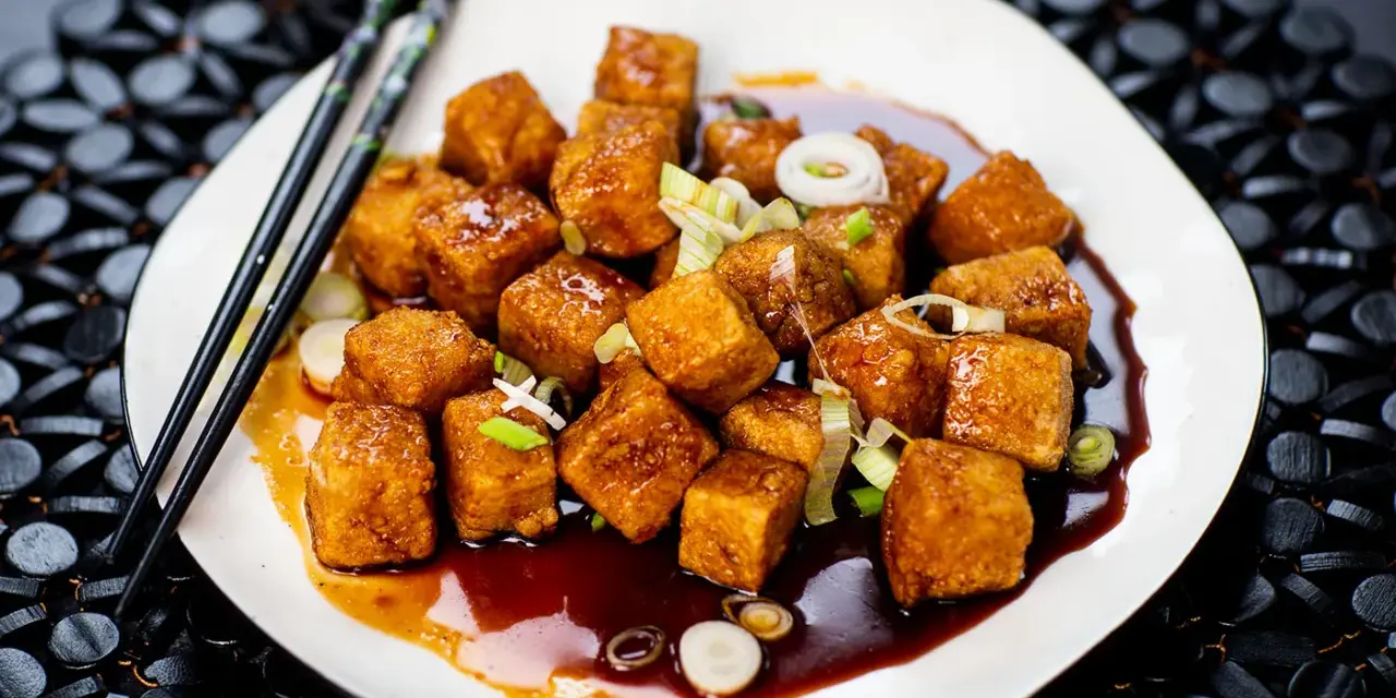 Krispiga, glaserade tofubitar med salladslök och en mörk sås. Ett läckert tofu recept som ser fantastiskt ut!