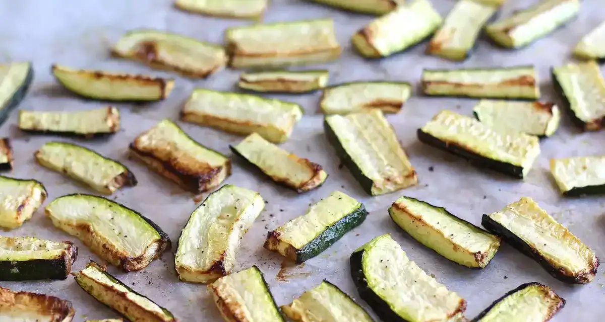 Skivor av zucchini i ugn, lätt gyllene och kryddade, redo att serveras.