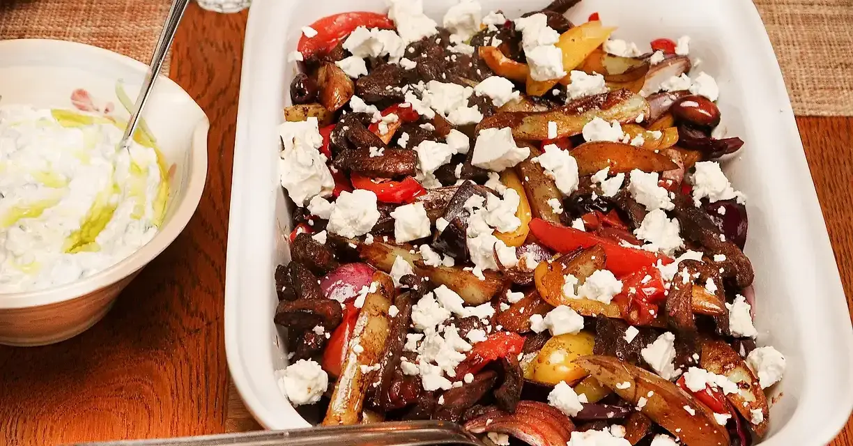 En härlig grekisk pyttipanna med potatis, paprika, lök och oliver, toppad med fetaost. Serveras med en krämig tzatziki.