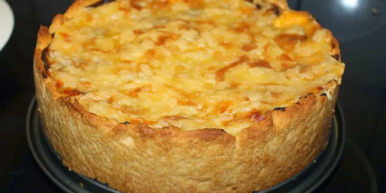 En gyllene kycklingpaj med ostigt täcke, perfekt för ett mysigt kycklingpaj recept.