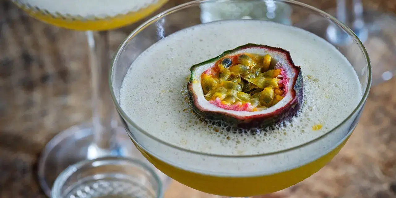 En lyxig Pornstar Martini med passionsfrukt som garnityr, serverad i ett elegant martiniglas.