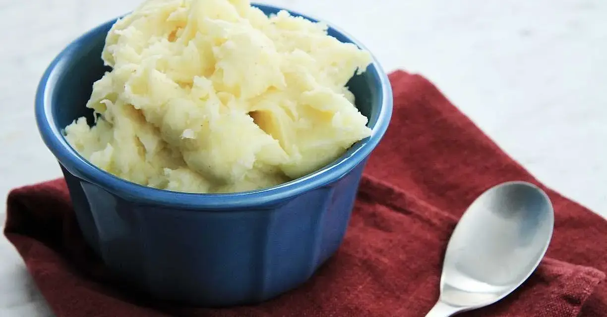 Krämigt potatismos i en blå skål, redo att serveras. Ett enkelt potatismos recept som passar till det mesta.