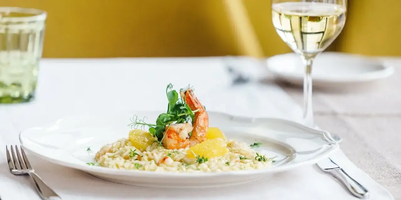 En krämig risotto med räkor och apelsin, perfekt ackompanjerad av ett glas vitt vin till risotto.