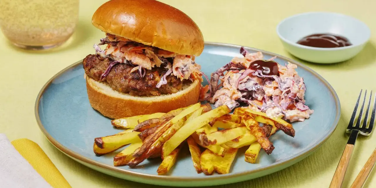 En saftig hamburgare med krispig coleslaw och pommes frites. Ett perfekt hamburgare recept för en härlig måltid.