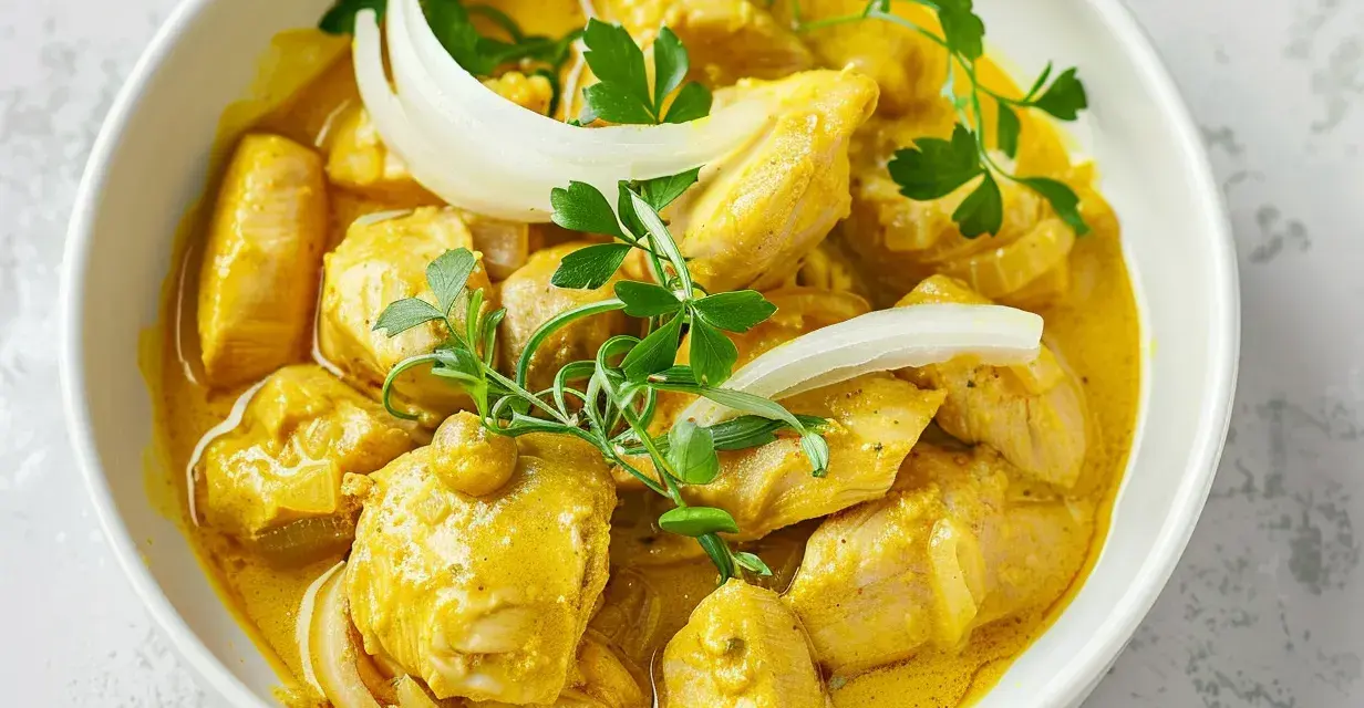 Krämig chicken a la king i en vit skål, garnerad med persilja och lök.