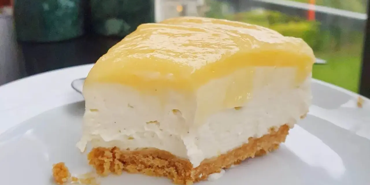 En krämig bit citron cheesecake med krispig botten, perfekt för en fika.