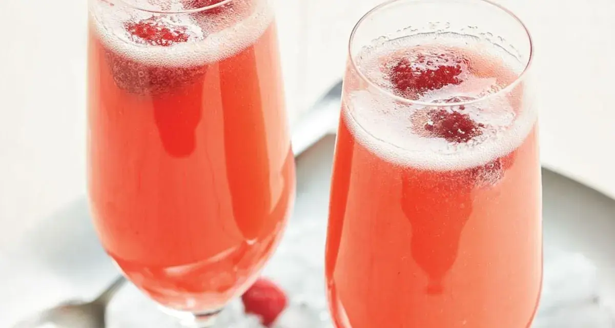 Två glas med ett rosa drink med bubbel och hallon. Perfekt för en festlig stund.