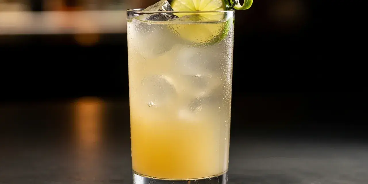 En uppfriskande limoncello sour med is, lime och en vacker spiraldekoration.