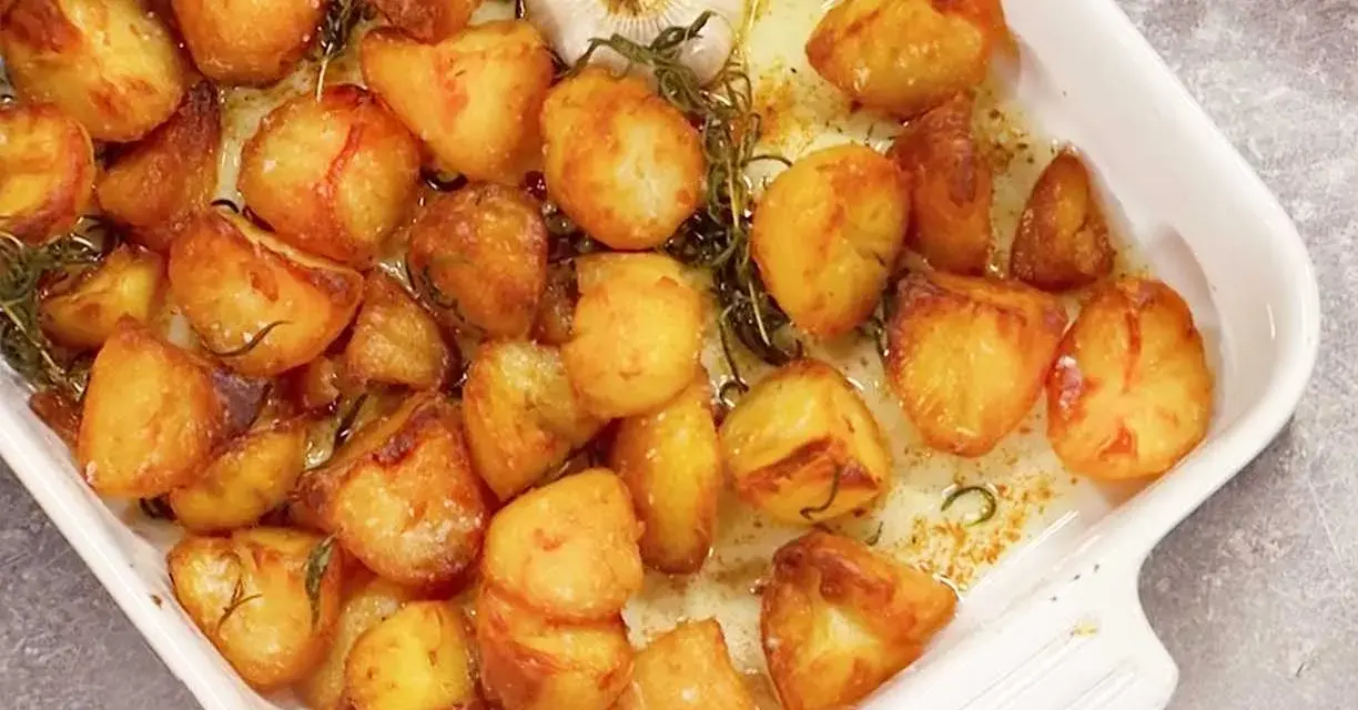 Ugnsrostad potatis med vitlök och rosmarin i en vit ugnsform. Perfekt tillbehör som doftar ljuvligt!