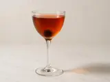 En klassisk manhattan drink med körsbär i ett elegant glas.