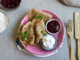 En tallrik med glutenfria pannkakor, serverade med sylt och grädde. En härlig frukost eller fika!