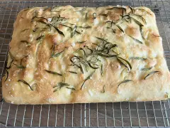 En gyllene, nybakad focaccia med rosmarin och flingsalt, perfekt för ditt nästa focaccia recept.