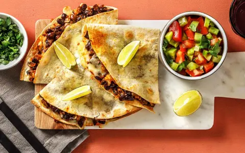 Läckra quesadillas med svarta bönor och ost, serverade med salsa och lime. Ett perfekt quesadillas recept för en snabb och smakrik måltid.