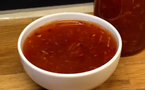 En skål med söt chili sås, redo att förhöja smaken på din favoritmat.