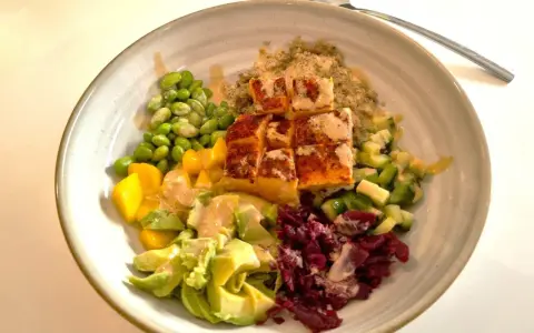 En vacker och hälsosam middagsbowl med lax, quinoa, edamamebönor, mango, avokado och rödbetor. Ett perfekt recept för en snabb och god middag.