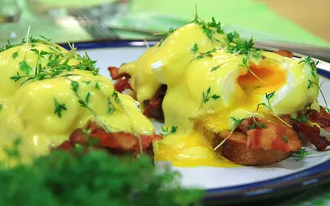 Läckra eggs benedict med krämig hollandaisesås, knaprigt bacon och färska örter. En perfekt start på dagen!