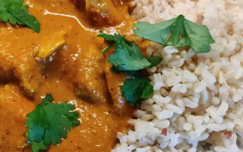 En krämig kycklingrätt med ris, perfekt för ett snabbt tikka masala recept. Garnerad med färsk koriander.