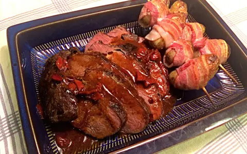 Helstekt entrecote i ugn, saftig och skivad, serveras med potatispaket inslagna i bacon. En festmåltid!