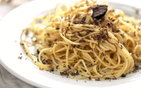 En tallrik med spaghetti toppad med rikligt med riven tryffel. Perfekt för en lyxig middag med ett gott vin till tryffelpasta.