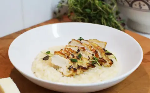 En krämig risotto med kyckling, toppad med färska örter och en bit parmesan. En perfekt risotto med kyckling för en härlig middag.