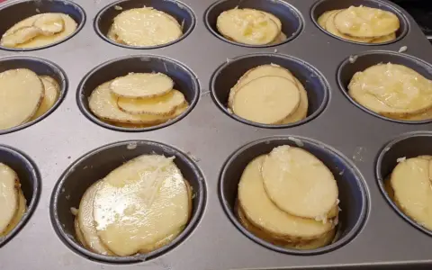 Tunna skivor av potatis i muffinsform, redo att bakas. Enkel och god rätt.