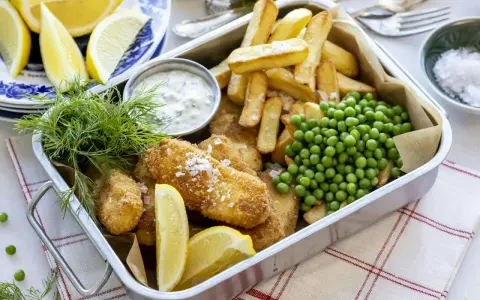 En krispig fiskgratäng med pommes frites, ärtor och citron. Perfekt för en snabb middag som hela familjen älskar.