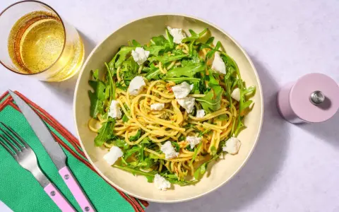 Spaghetti med ruccola och fetaost, ett enkelt zucchini recept. Serveras med ett glas bubbel.