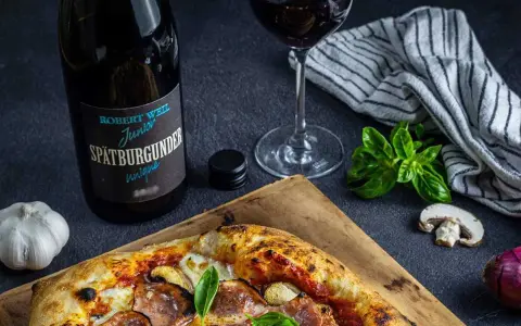En pizza med svamp och skinka, en flaska Spätburgunder och ett glas rött vin. Perfekt vin till gås!