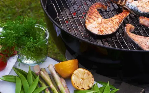 Grilla lax på gasolgrill med färska grönsaker och citron.