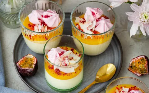 Vackra glas med pannacotta påsk, toppad med passionsfruktscurd, maräng och kokosflingor. En festlig dessert!