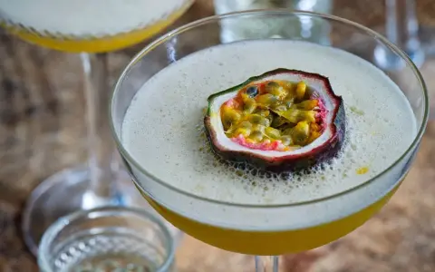 En lyxig Pornstar Martini med passionsfrukt som garnityr, serverad i ett elegant martiniglas.