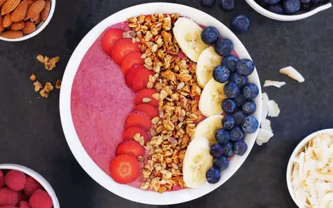 En färgglad acai bowl med jordgubbar, banan, blåbär och granola. Perfekt för en hälsosam frukost eller mellanmål.