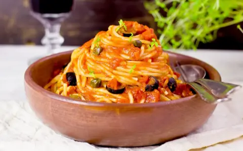 En härlig portion spaghetti med en smakrik tomatsås, oliver och kapris. Perfekt vin till pasta puttanesca.