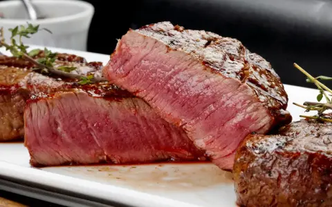 Perfekt grillad oxfilé med saftig rosa kärna, serverad med en glansig glaze och färsk timjan.