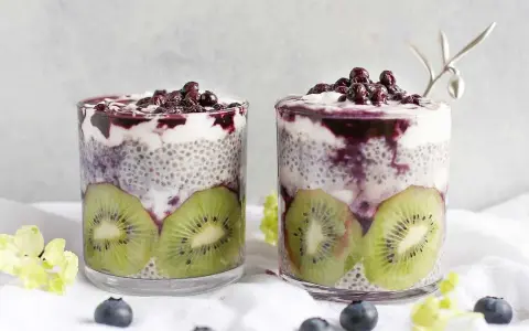 Två glas med chiapudding kvarg, kiwi och blåbär. En härlig frukost eller mellanmål.