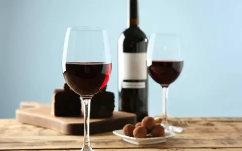 Två glas rött vin, en flaska, chokladpraliner och en bit chokladkaka. En perfekt kombination av vin till choklad.
