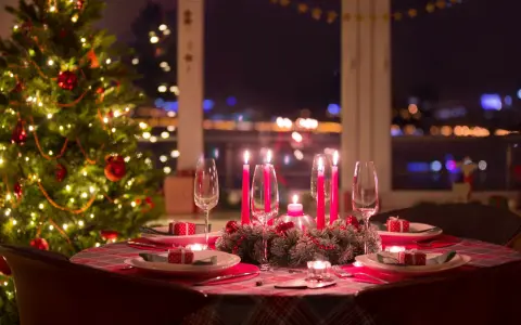 Ett dukat bord med julgran och tända ljus, redo för ett härligt vin till julbordet.