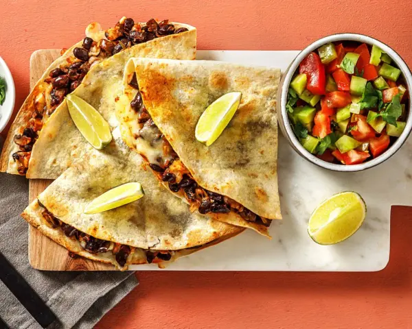 Läckra quesadillas med svarta bönor och ost, serverade med salsa och lime. Ett perfekt quesadillas recept för en snabb och smakrik måltid.