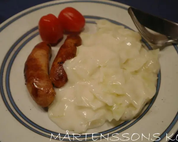 En tallrik med stuvad vitkål, korv och tomater. En klassisk svensk husmanskosträtt.