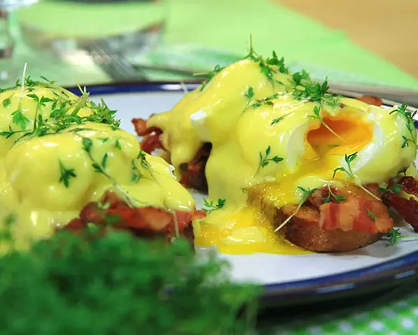 Läckra eggs benedict med krämig hollandaisesås, knaprigt bacon och färska örter. En perfekt start på dagen!