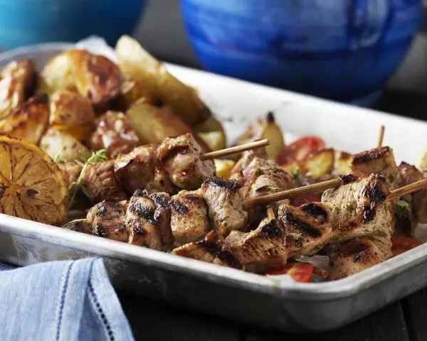 Grillade souvlaki-spett med rostade potatisar och citronklyftor. Ett perfekt souvlaki recept för en härlig middag.